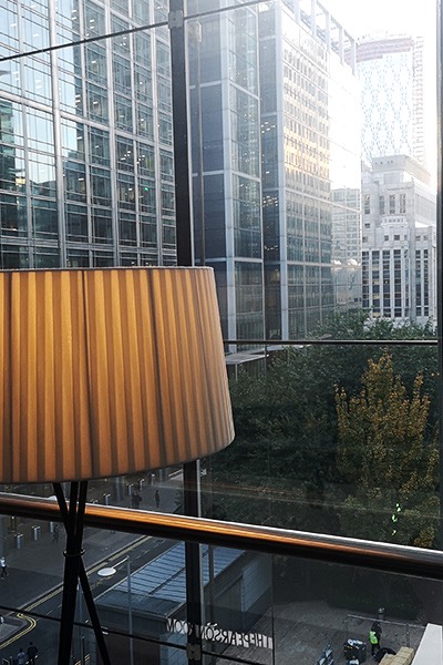 Image of a lamp in front of window with a view of the London financial district